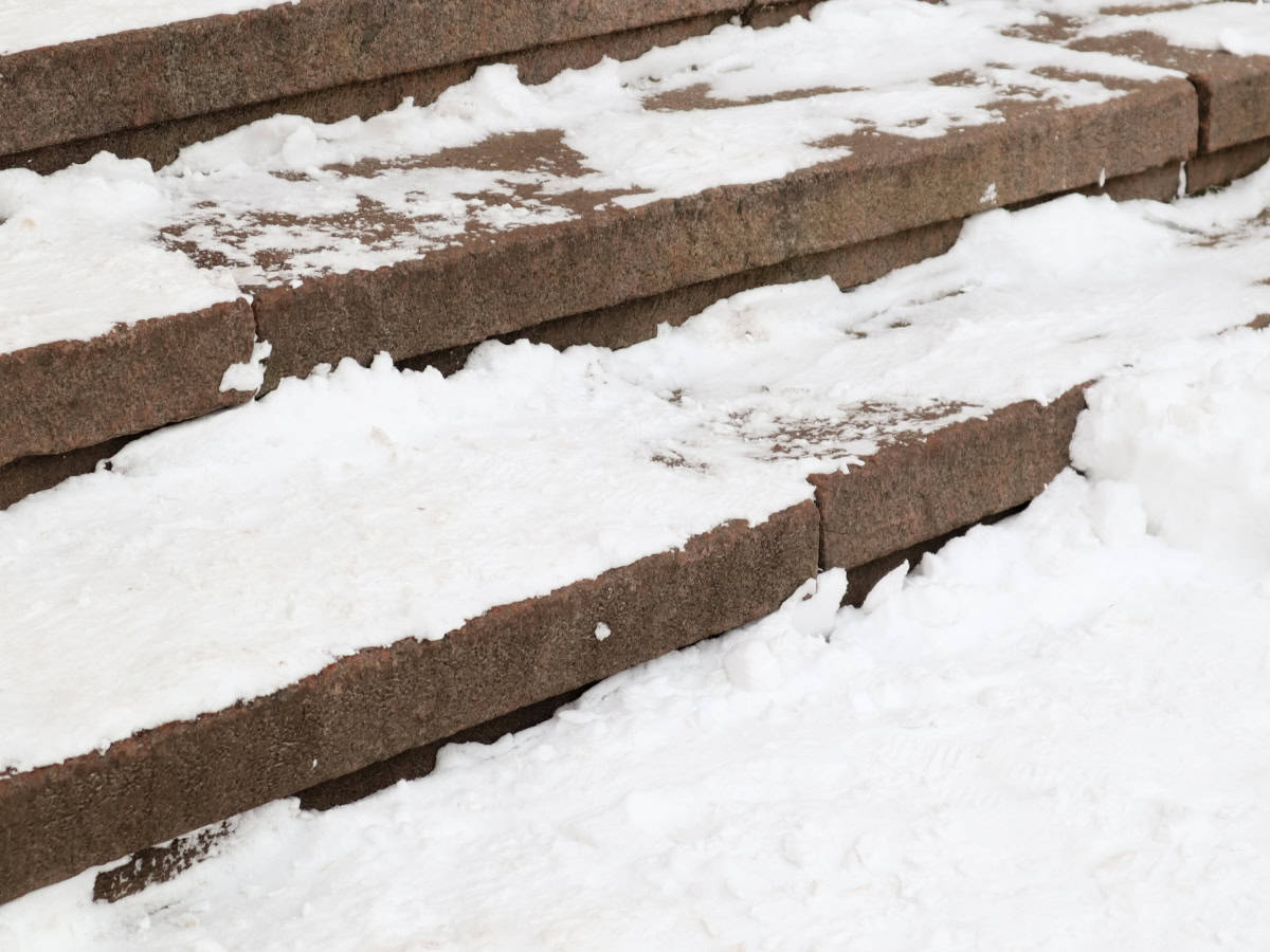 Homeowner preparing a driveway for liquid de-icer application