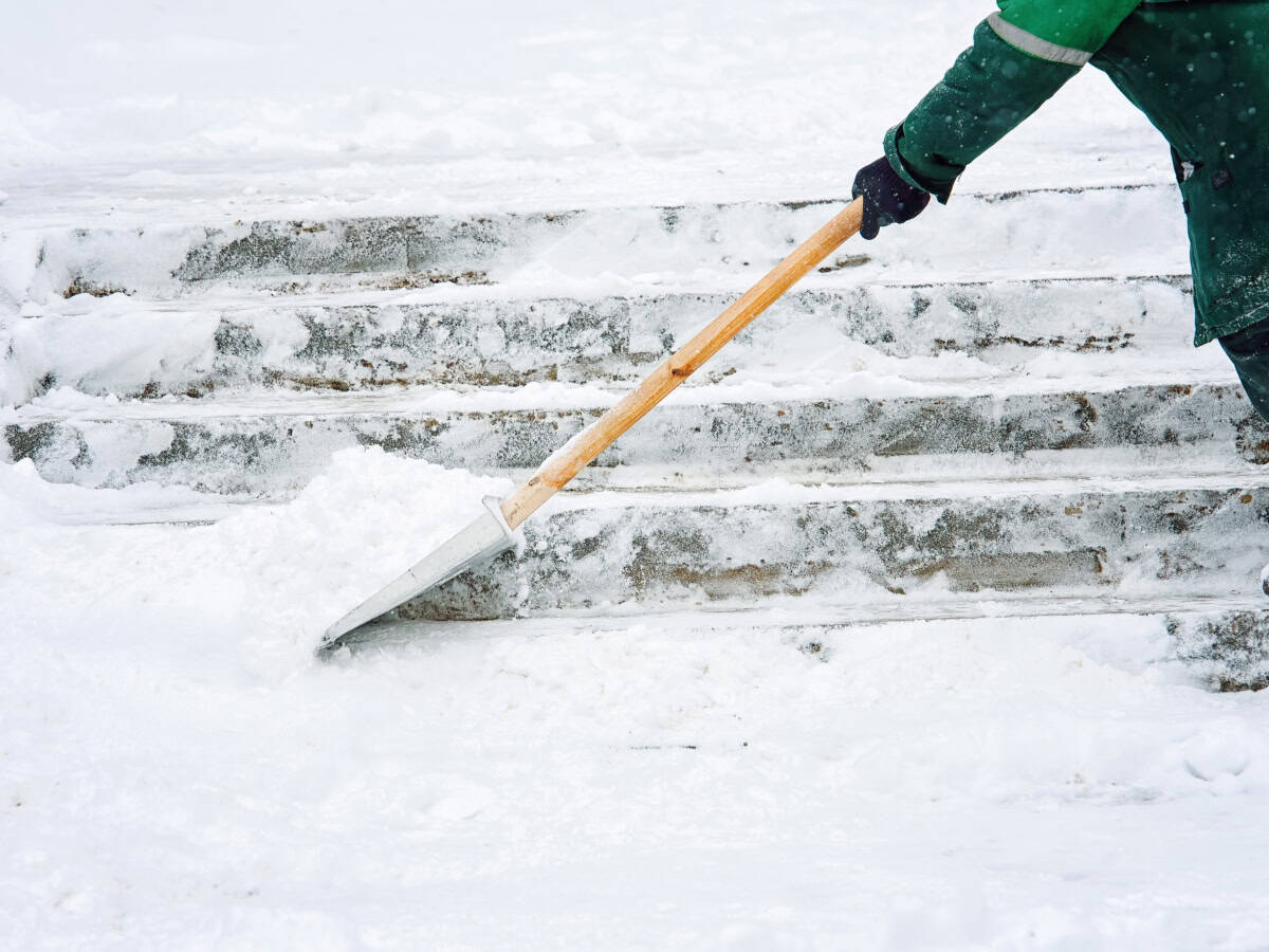 Applying liquid ice melt to a residential walkway with a hand sprayer