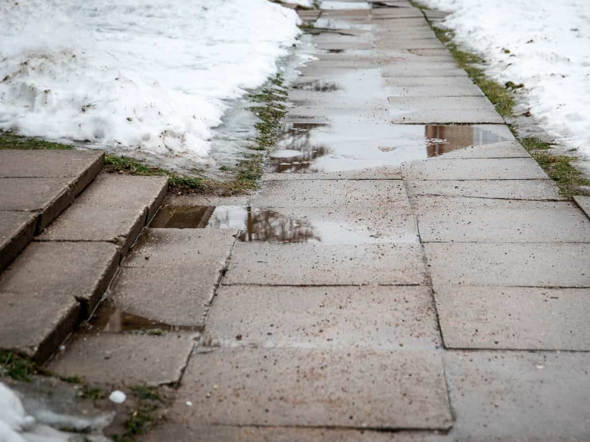 Liquid de-icer breaking the bond between ice and pavement