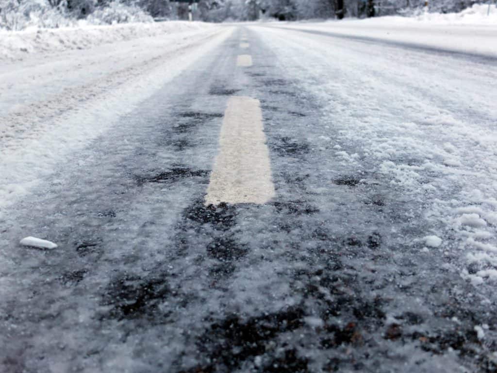 Close-up of calcium chloride liquid melting ice on a treated surface